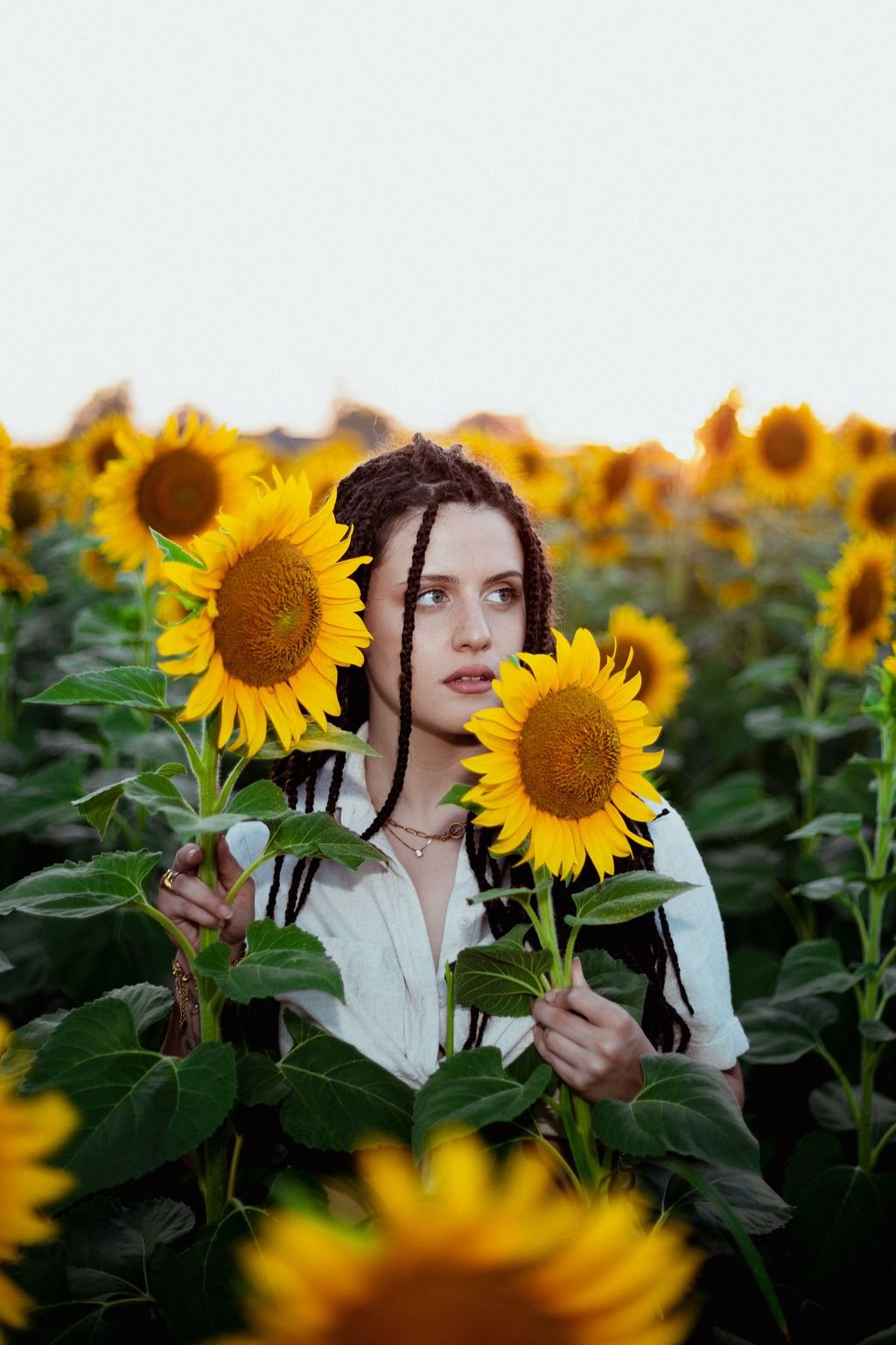 Nemi fra due girasoli, con le treccine sulla camicia bianca